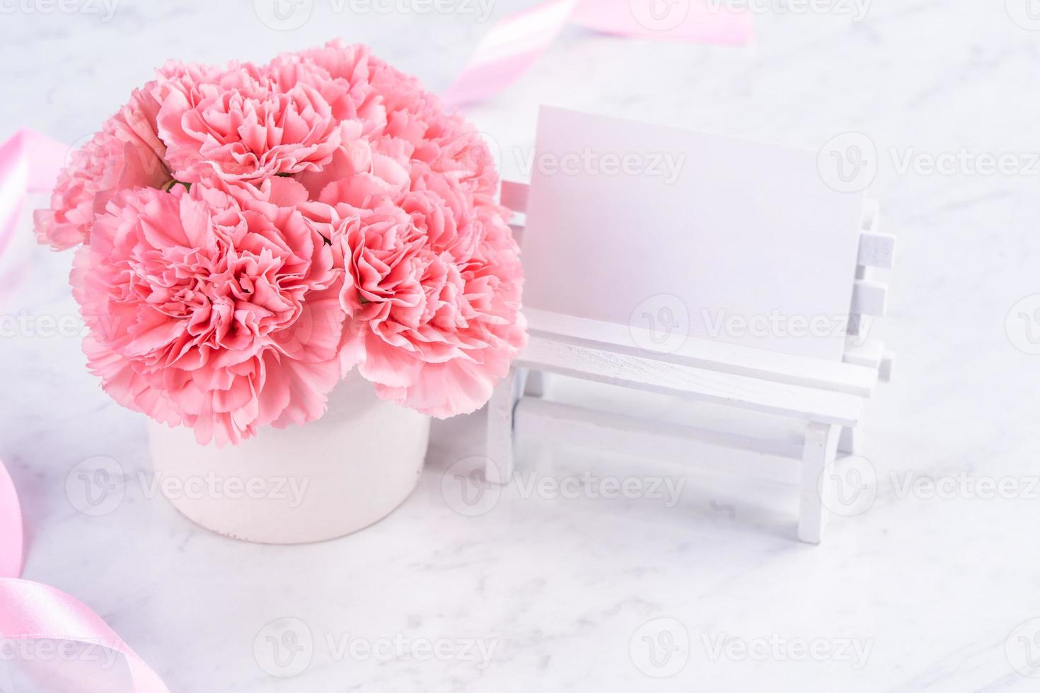 Copy space, close up, mock up, clipping path. Mothers day wording concept design. Beautiful fresh blooming baby pink color carnations isolated on bright marble background. photo