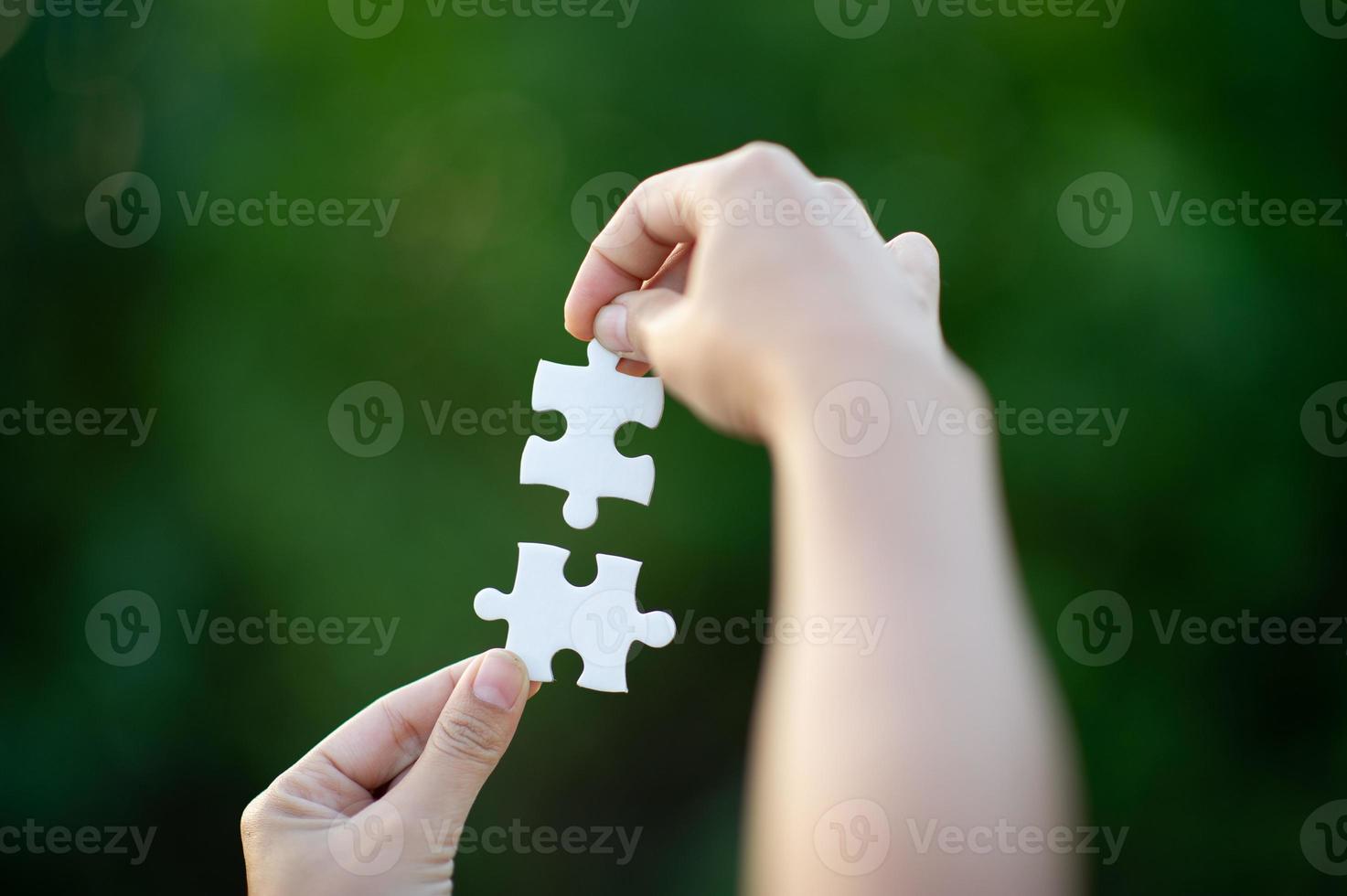 Hands and white jigsaw puzzles Close-up image and integration Business concept and unity photo