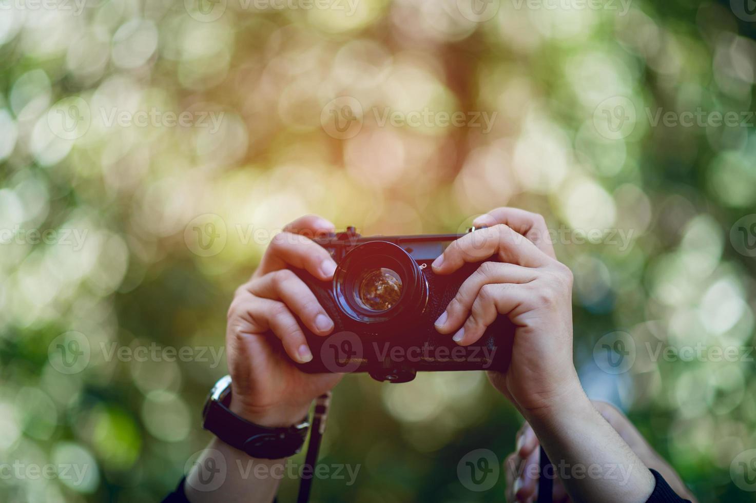 la mano y la cámara del fotógrafo viajan por las montañas y el fotógrafo del concepto de naturaleza foto