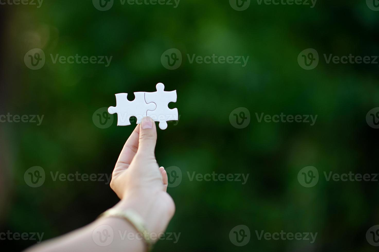 Hands and white jigsaw puzzles Close-up image and integration Business concept and unity photo