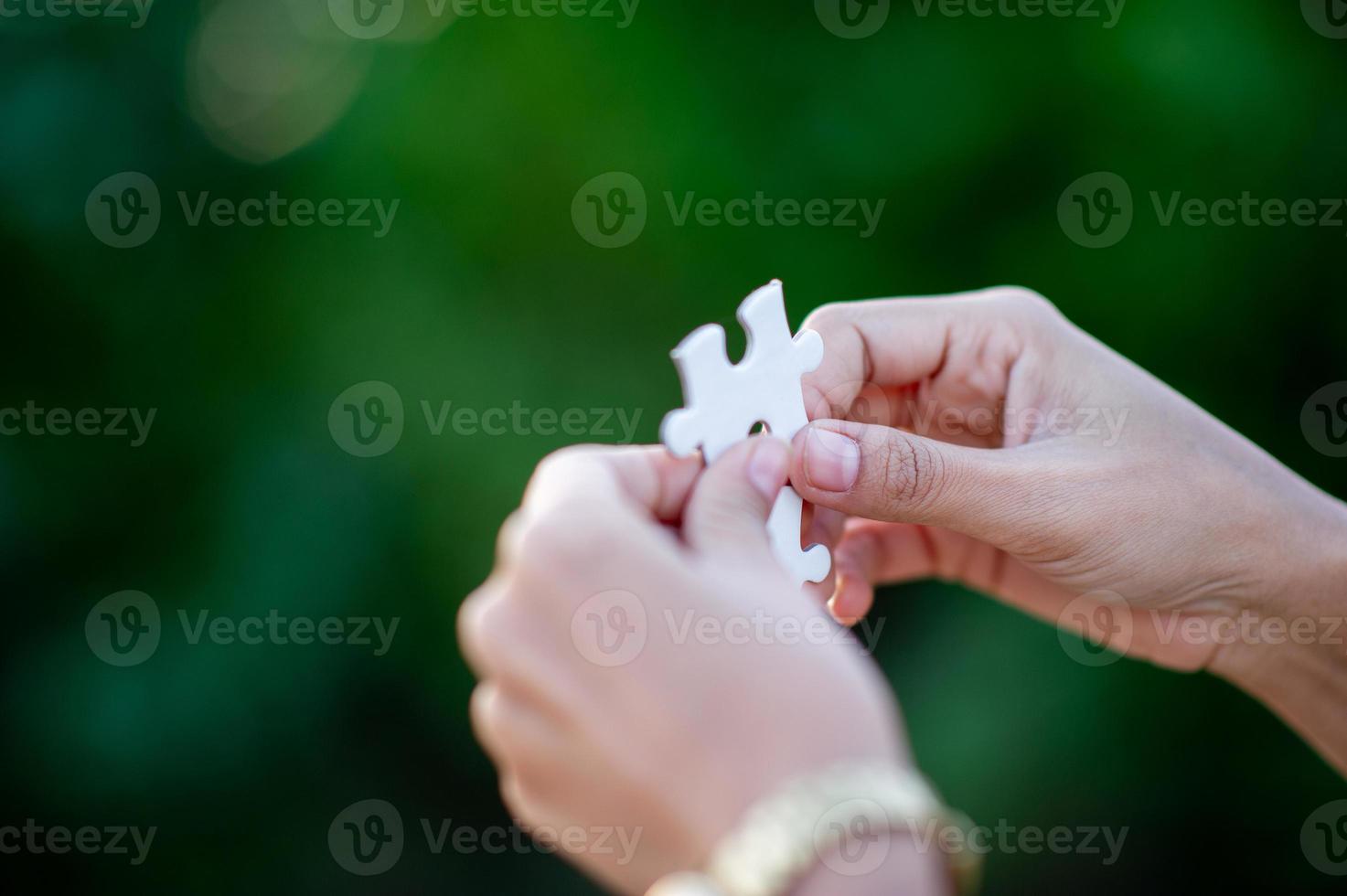 Hands and white jigsaw puzzles Close-up image and integration Business concept and unity photo