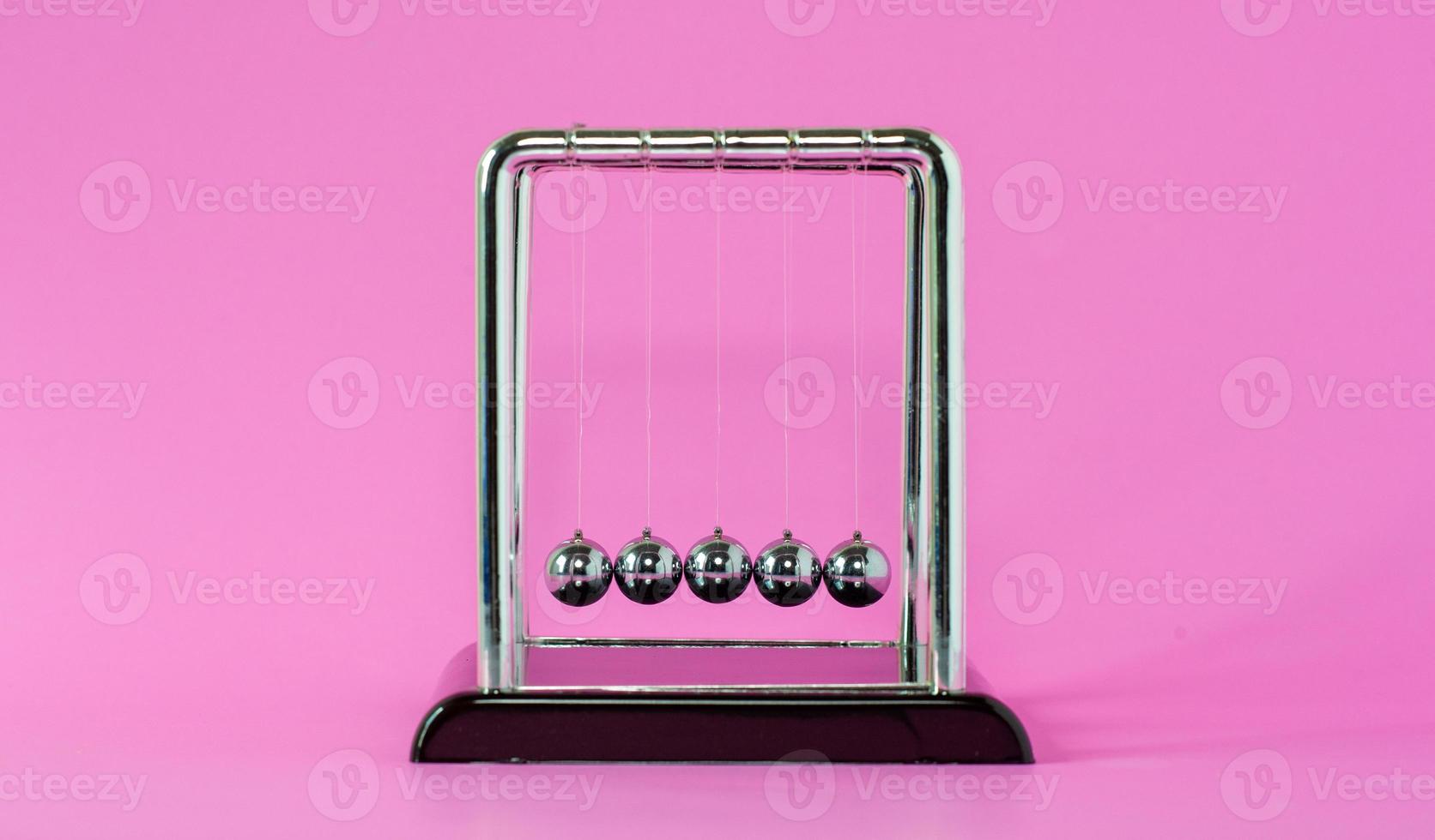 Newton's cradle physics concepts for action and reaction or cause and effect On the pink background photo