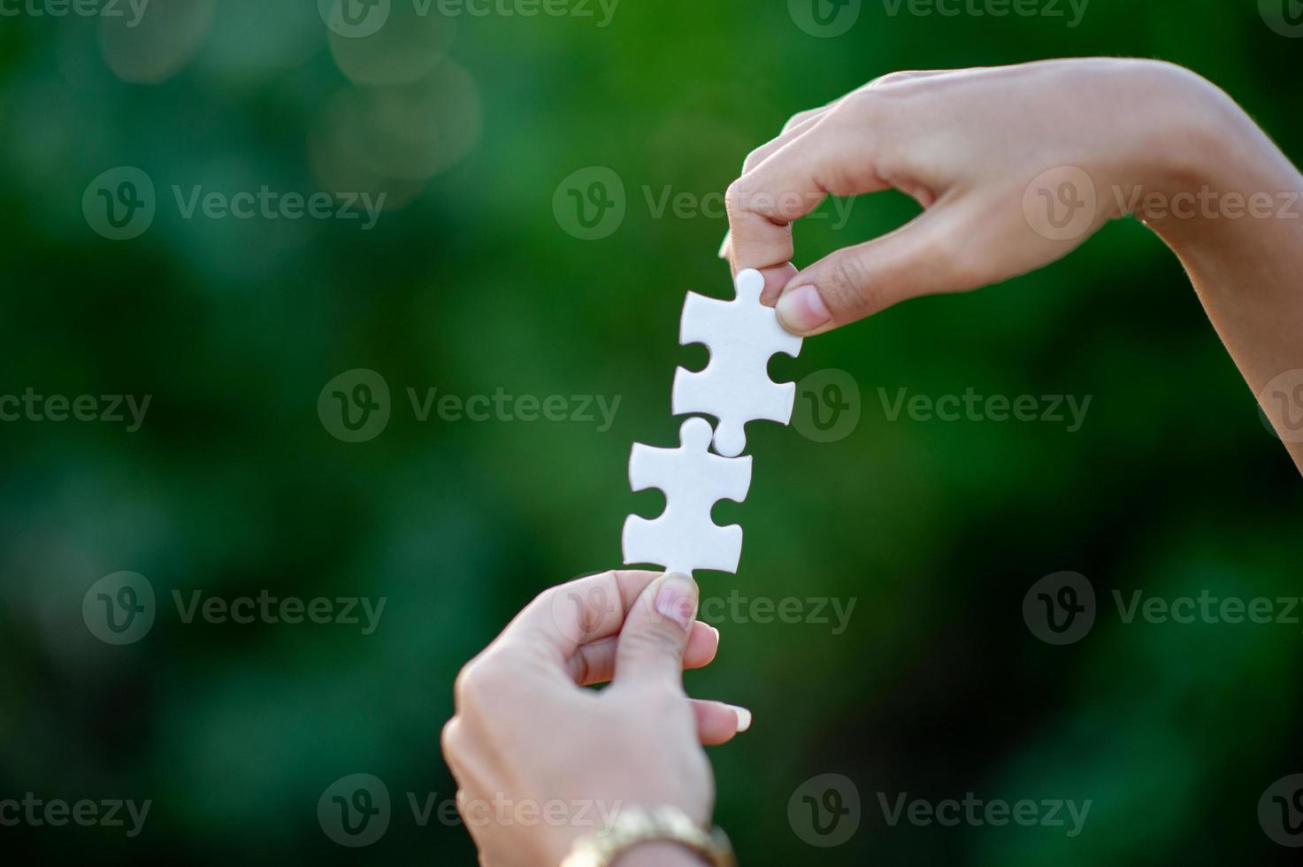 Hands and white jigsaw puzzles Close-up image and integration Business concept and unity photo
