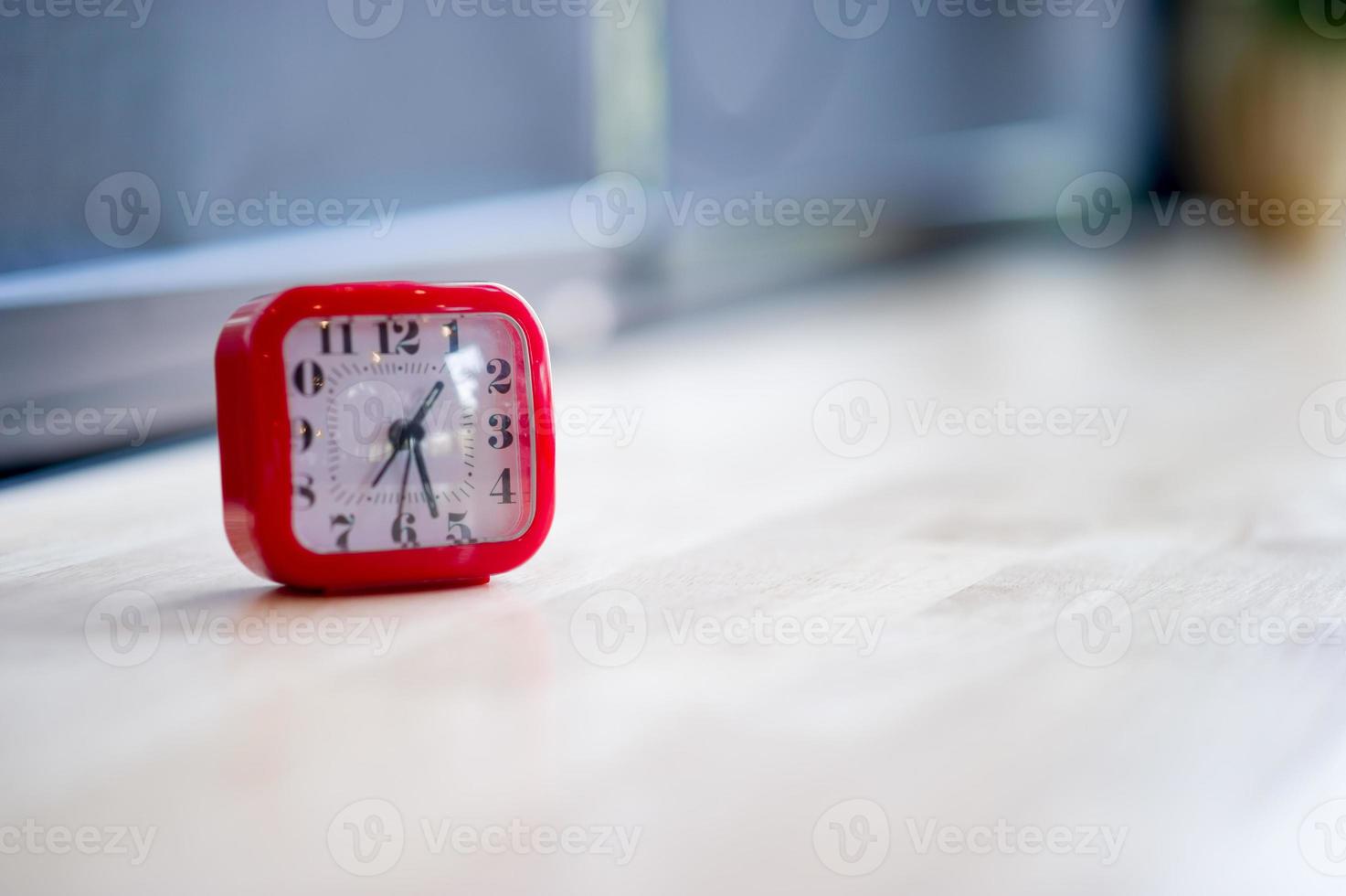 Red alarm clock Placed on colorful wooden floors, time concept photo