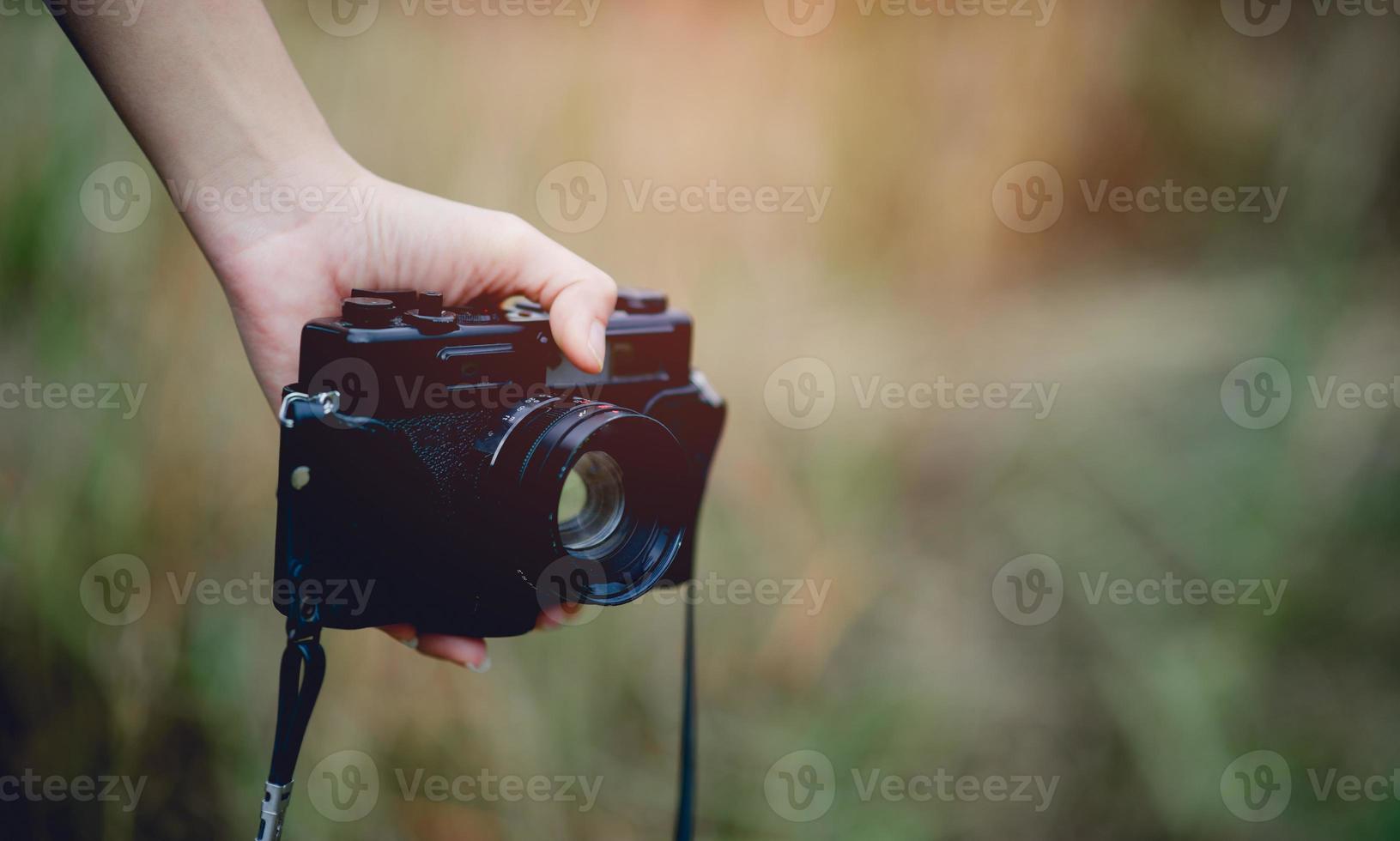 mano y cámara del fotógrafo sosteniendo y llevando la cámara para tomar fotografías foto