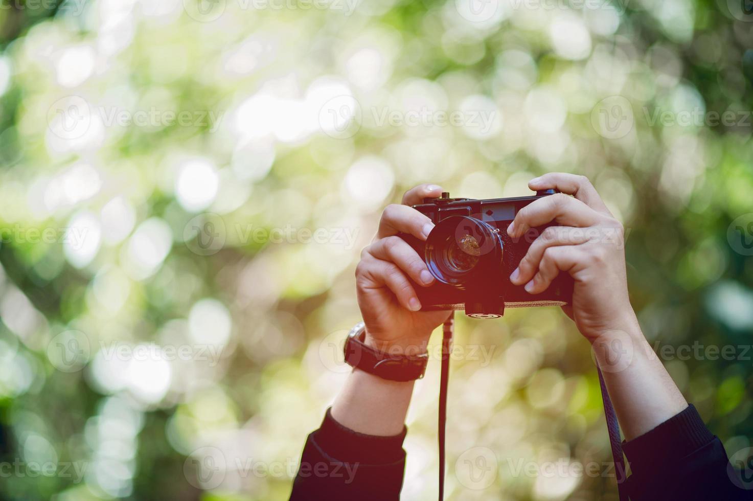 Hand and camera of the photographer Travel in the mountains and nature Concept photographer photo