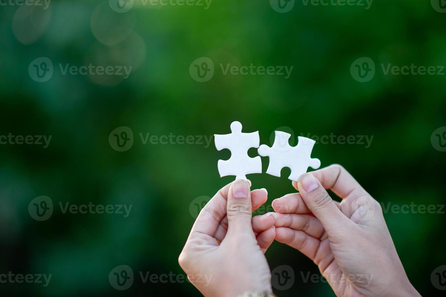 Hands and white jigsaw puzzles Close-up image and integration Business concept and unity photo