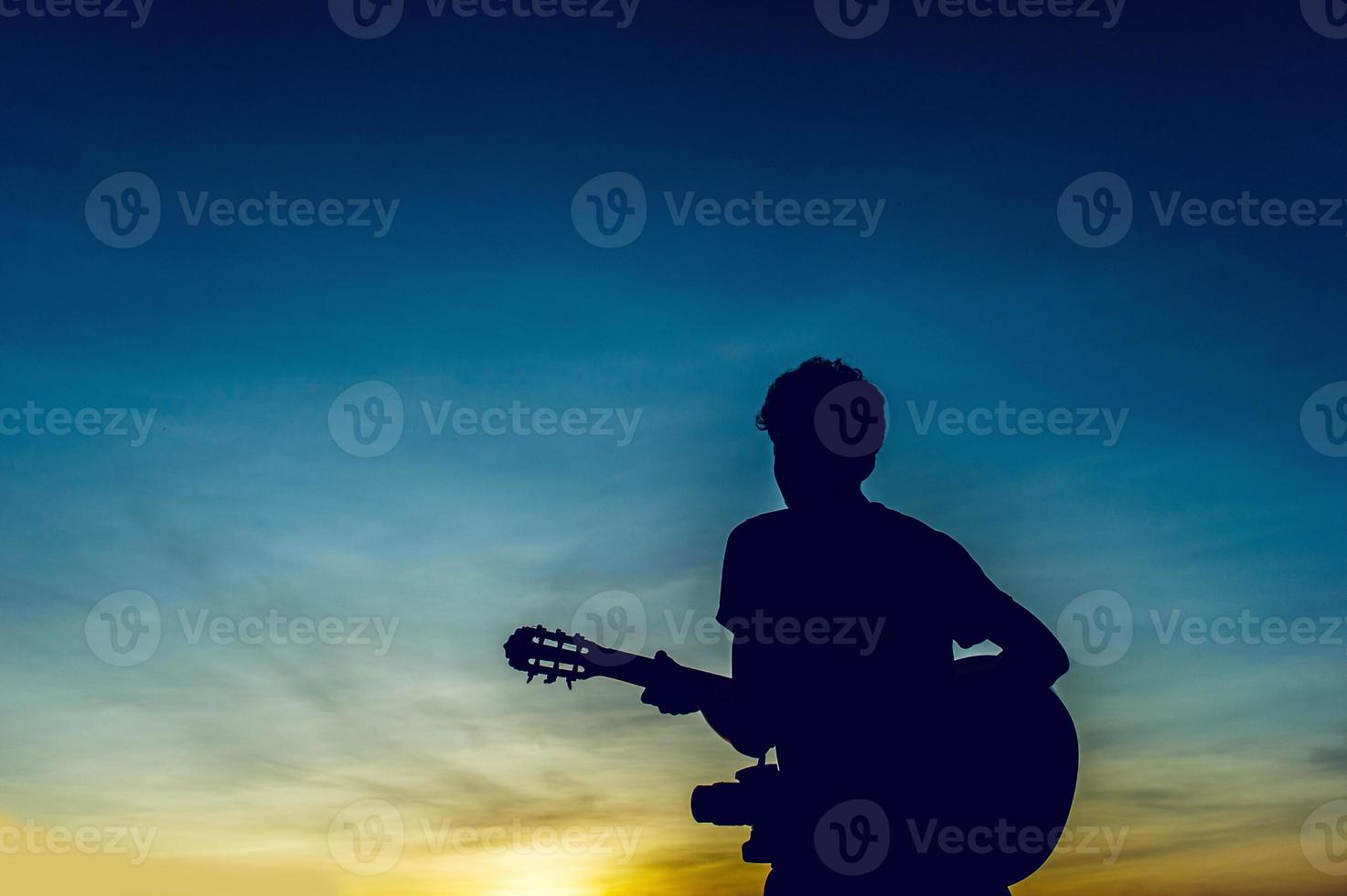 Silhouette of a guitarist in the shadows at sunset light, silhouette concept. photo