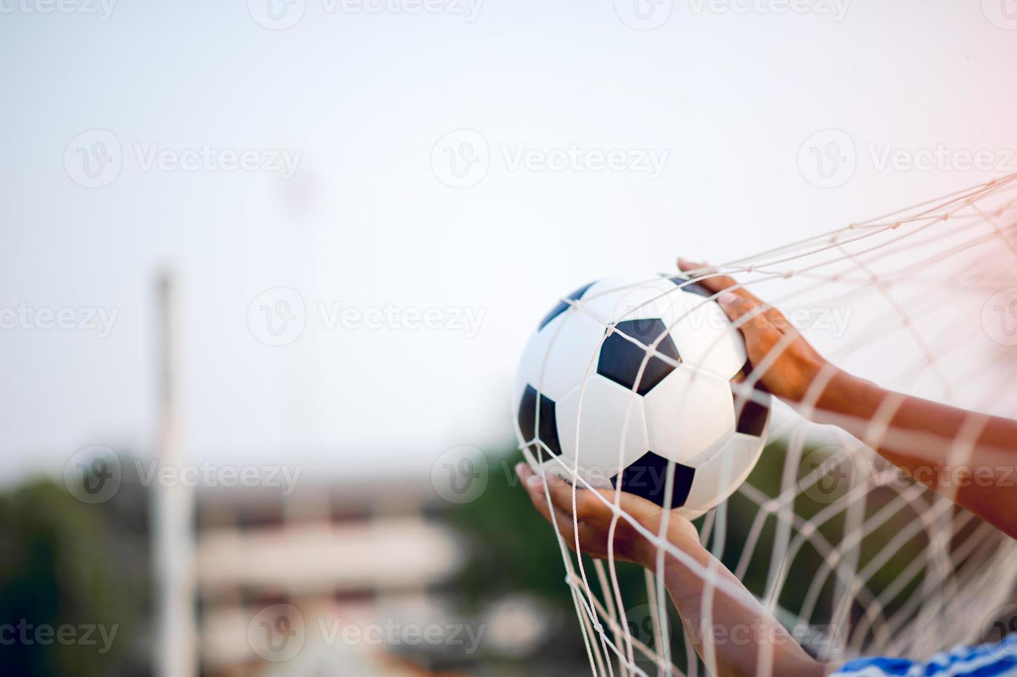 la imagen recortada de deportistas que atrapan la pelota y el campo de fútbol. concepto de imagen deportiva. foto