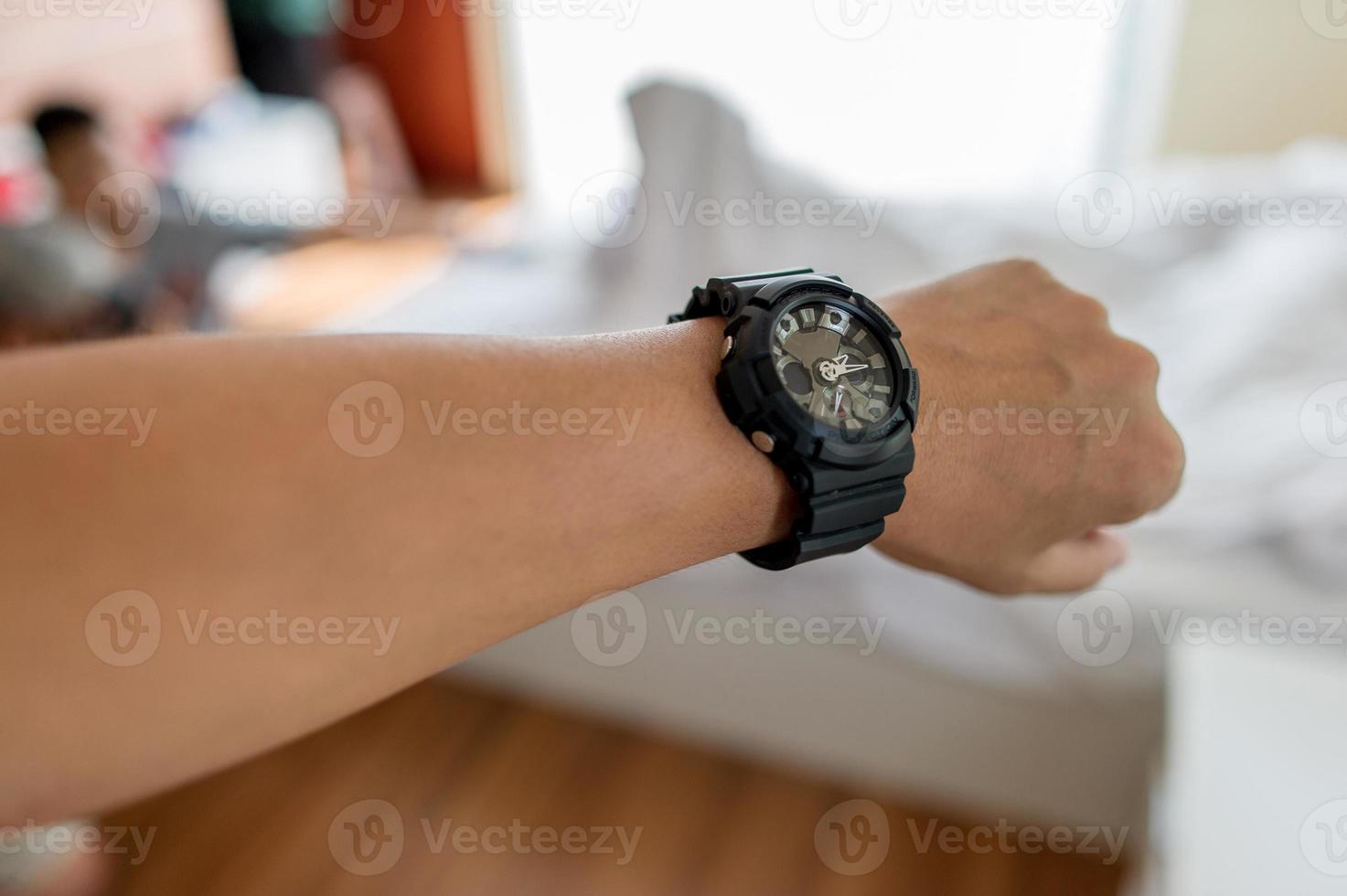 Hands and black watches of young men who like time concept watches photo