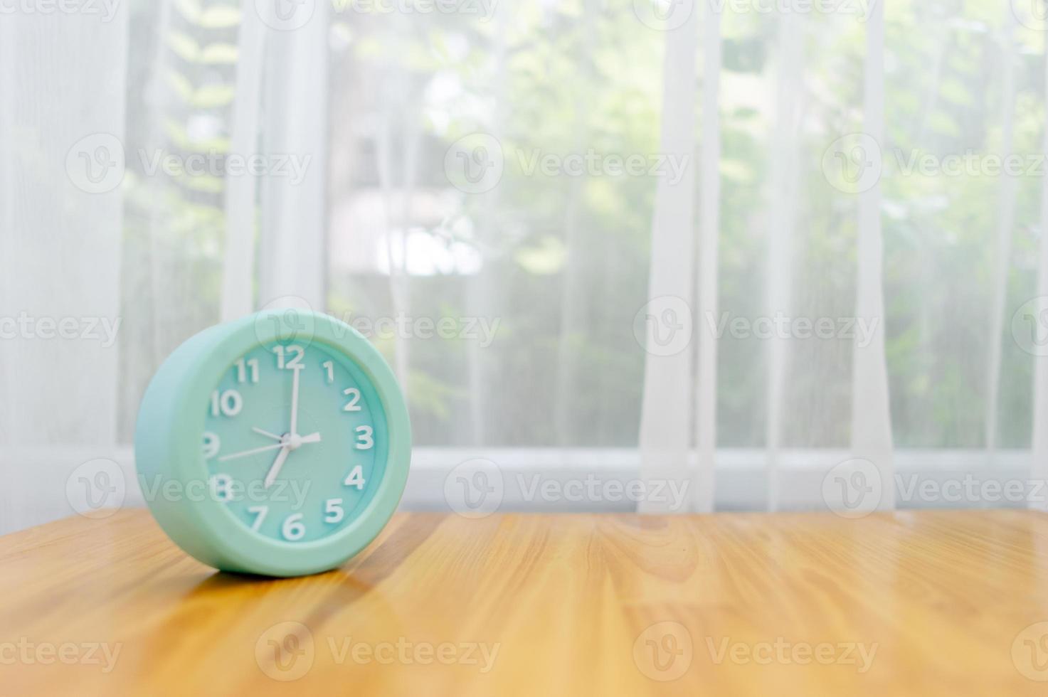 despertador verde claro colocado sobre la mesa en el dormitorio foto