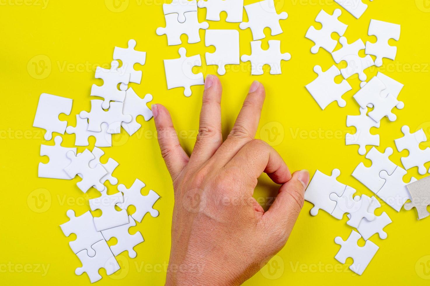 Jigsaw and hands on the yellow concept background photo