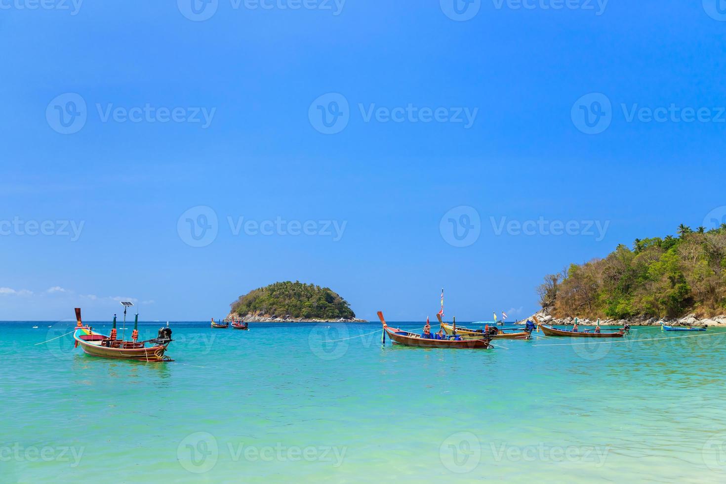 mar azul turquesa cristalino y barco de pesca tradicional de madera en la playa de kata, phuket, tailandia foto