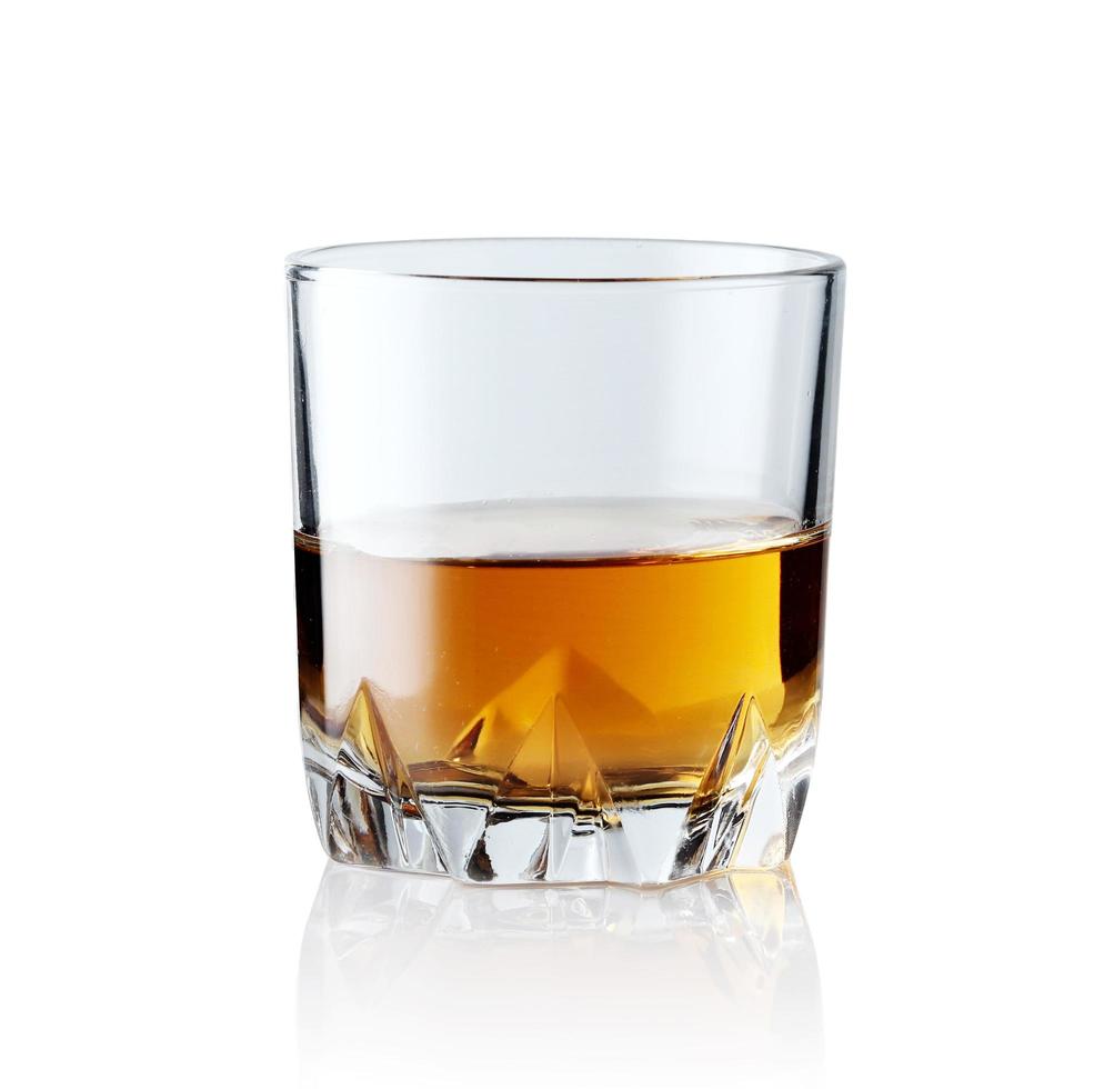 Scotch whiskey in an elegant glass on a white background with reflections. photo