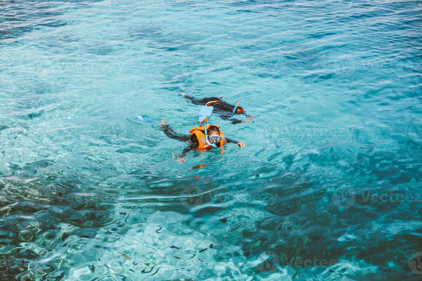 A woman tourists is swimming on the transparent sea photo