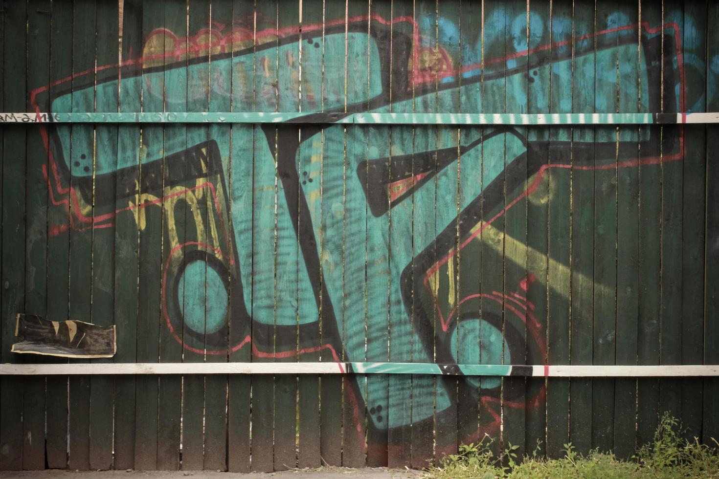 Green wooden wall with graffiti in the forest photo