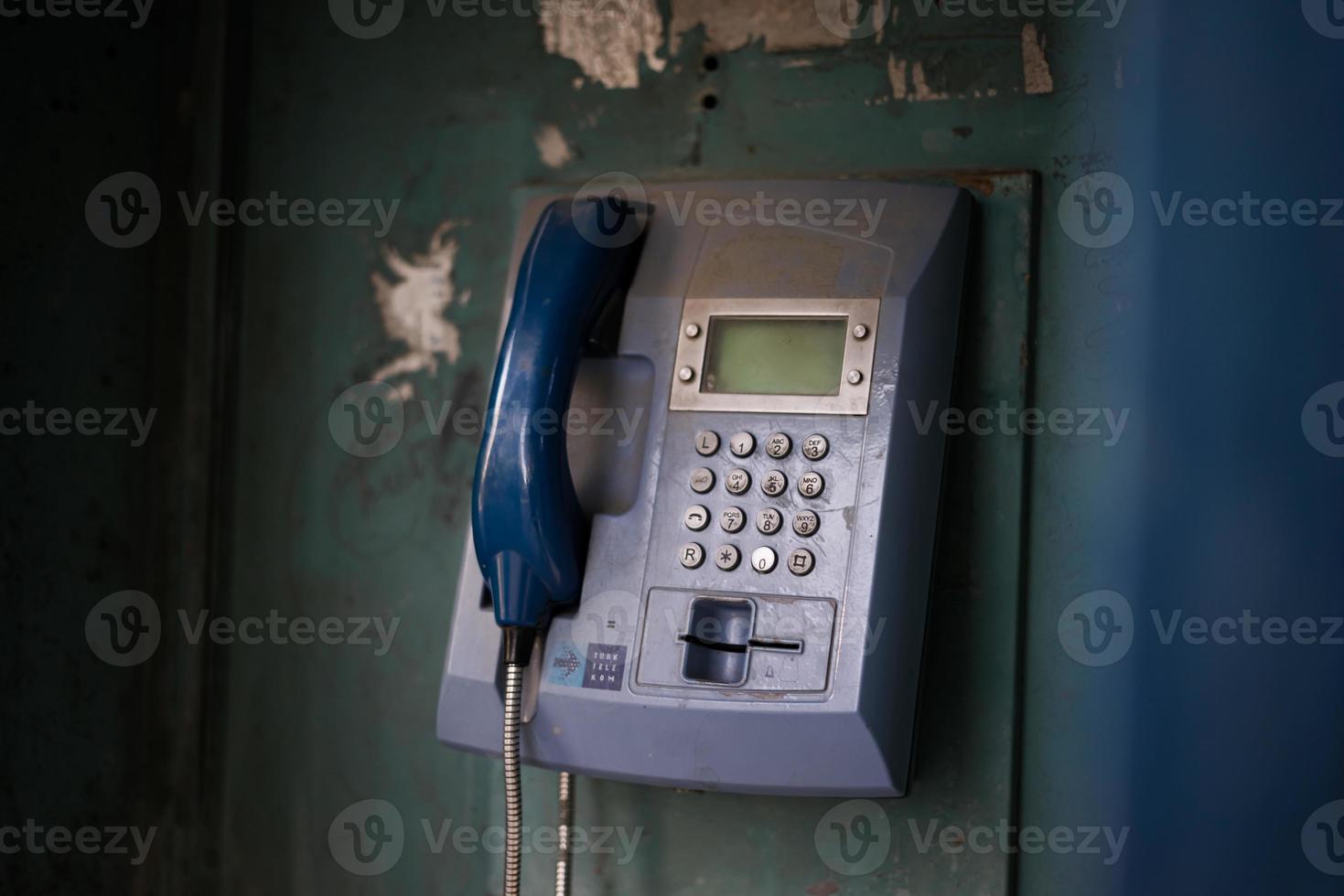 antigua cabina telefónica azul con números con luz cinematográfica en estambul foto