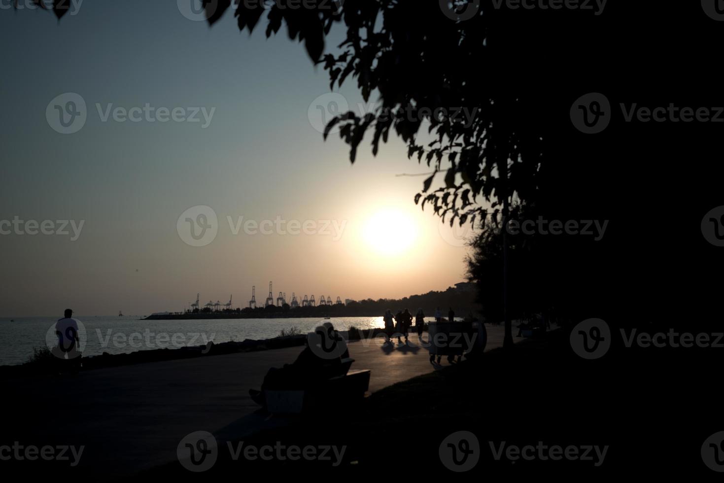 Sun glare and walking people silhouettes photo