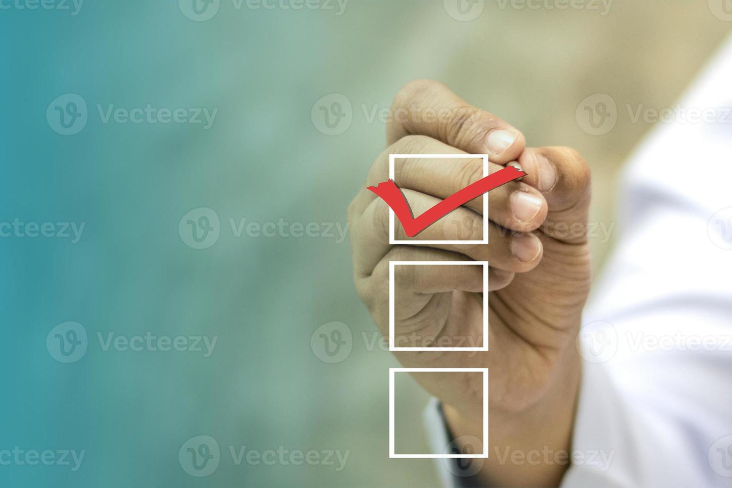 Businessman holds a pen with a choice of voting boxes photo