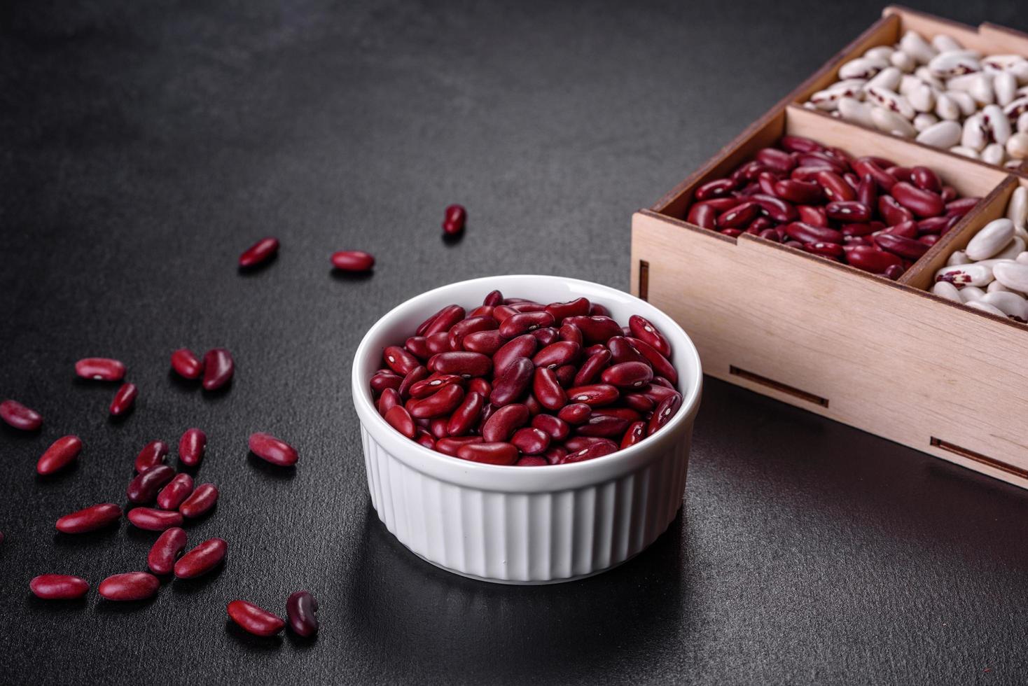 frijoles de frijoles crudos secos rojos sobre un fondo de hormigón oscuro foto