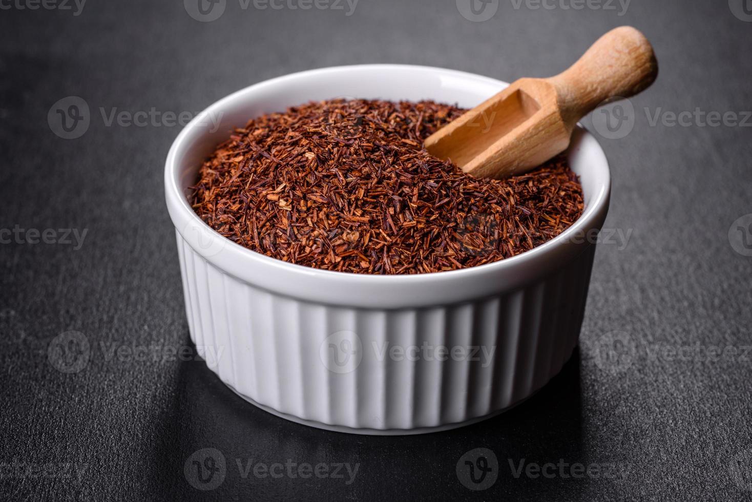 Rooibos tea on a black background. Flat lay, copy space photo