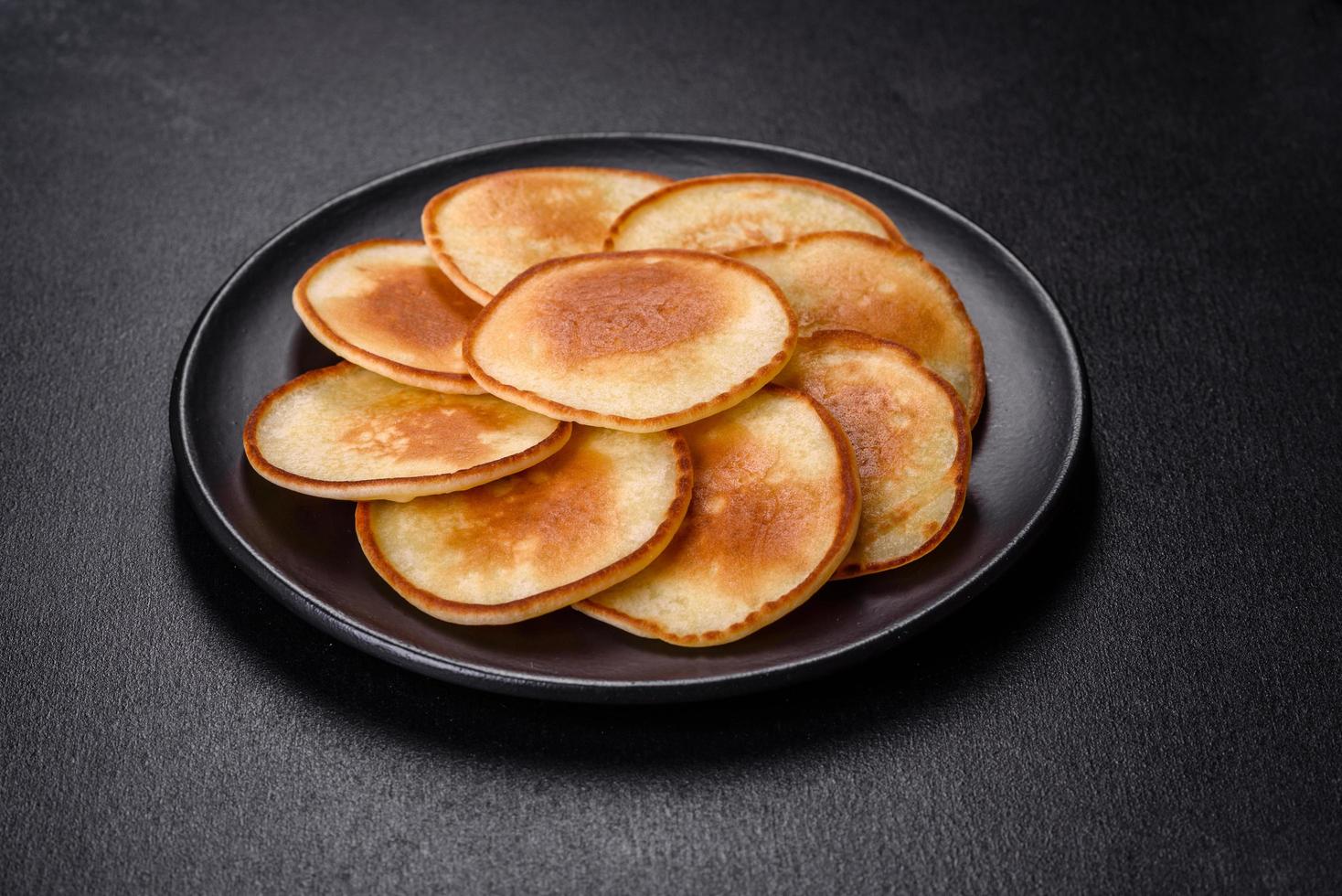 Delicious fresh pancakes on a wooden cutting board with sugar photo