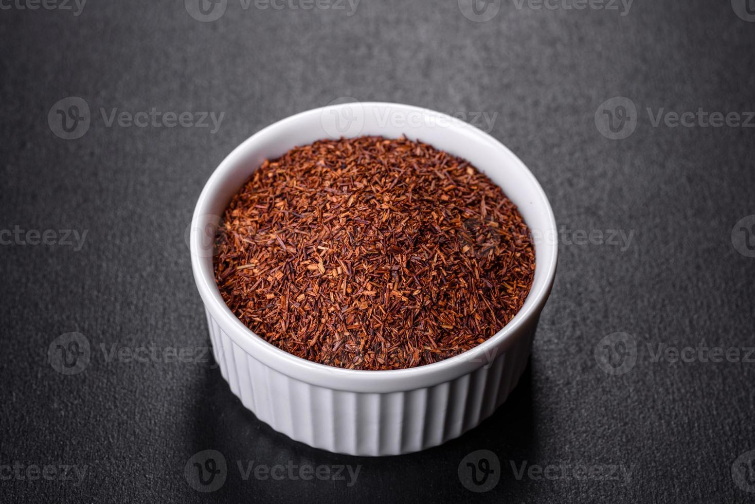 Rooibos tea on a black background. Flat lay, copy space photo