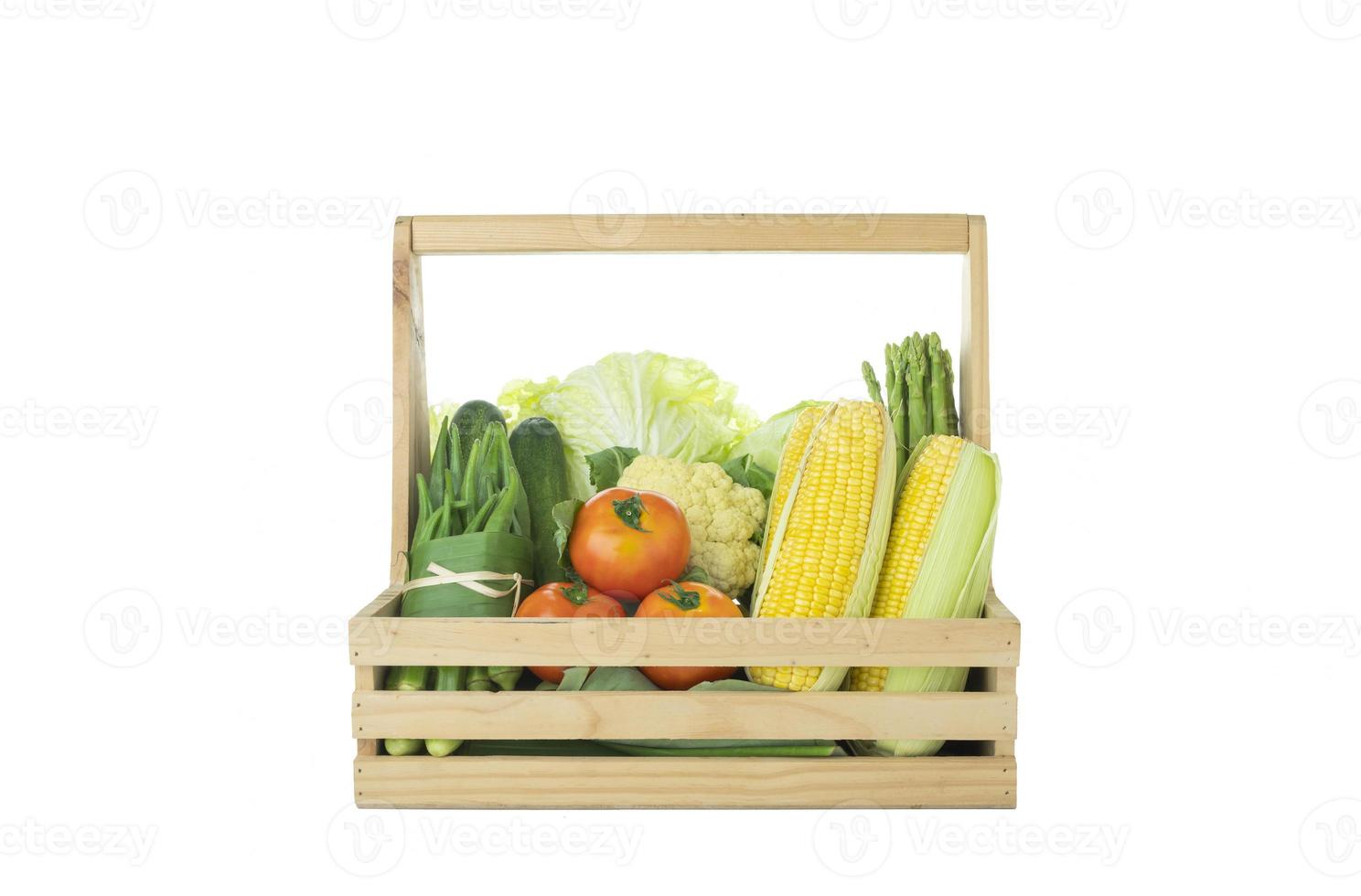 Various fresh organic vegetables in wooden basket on isolated white background photo