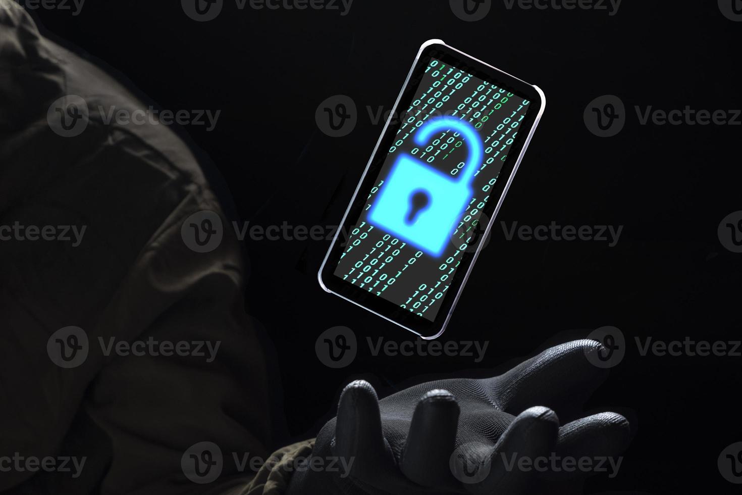 Close up illuminate unlock icon with green binary code on screen of smartphone floating above of hacker's hand in black glove on dark background, hacking and internet cyber crime concept photo