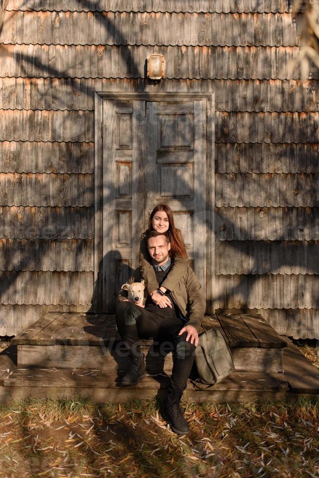 Lovely couple spending autumn day outdoors with their dog photo