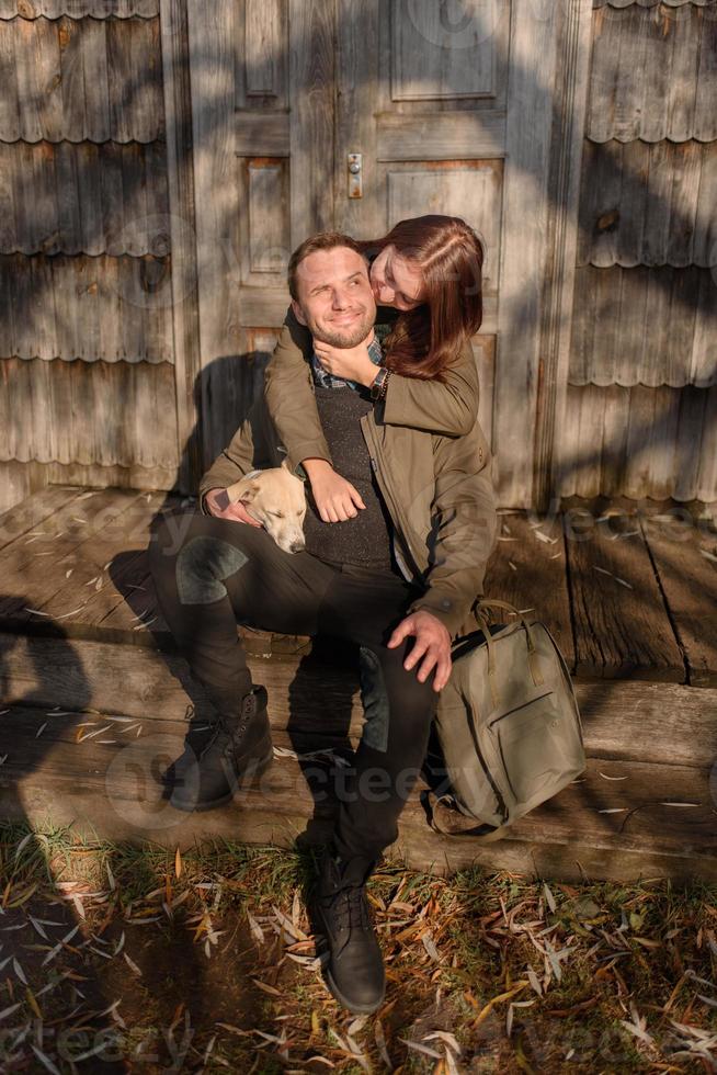 encantadora pareja pasando el día de otoño al aire libre con su perro foto