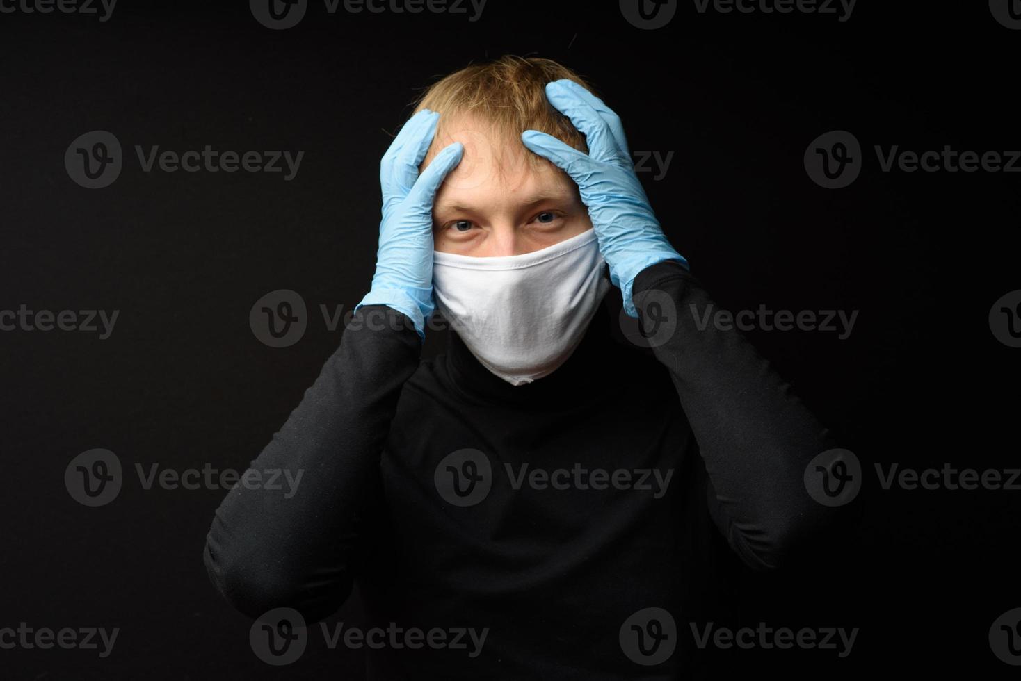 Protection against contagious disease, coronavirus. Man wearing hygienic mask to prevent infection 2019-nCoV. man's panic man puts on protective gloves photo