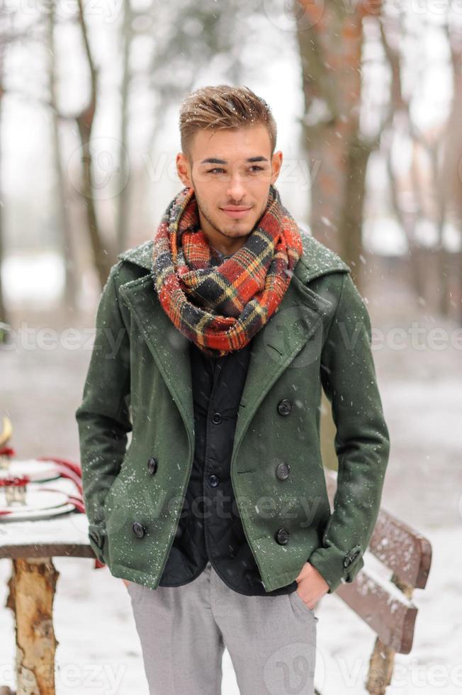 Portrait of a bearded groom in a stylish suit with suspenders and bow-tie in winter at a ski resort photo