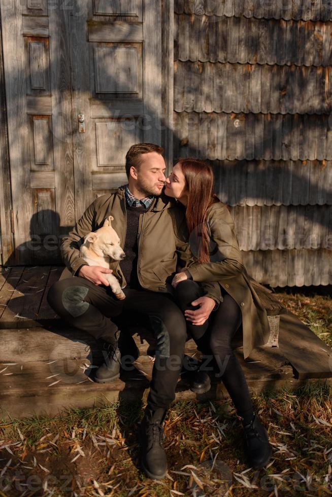 Lovely couple spending autumn day outdoors with their dog photo