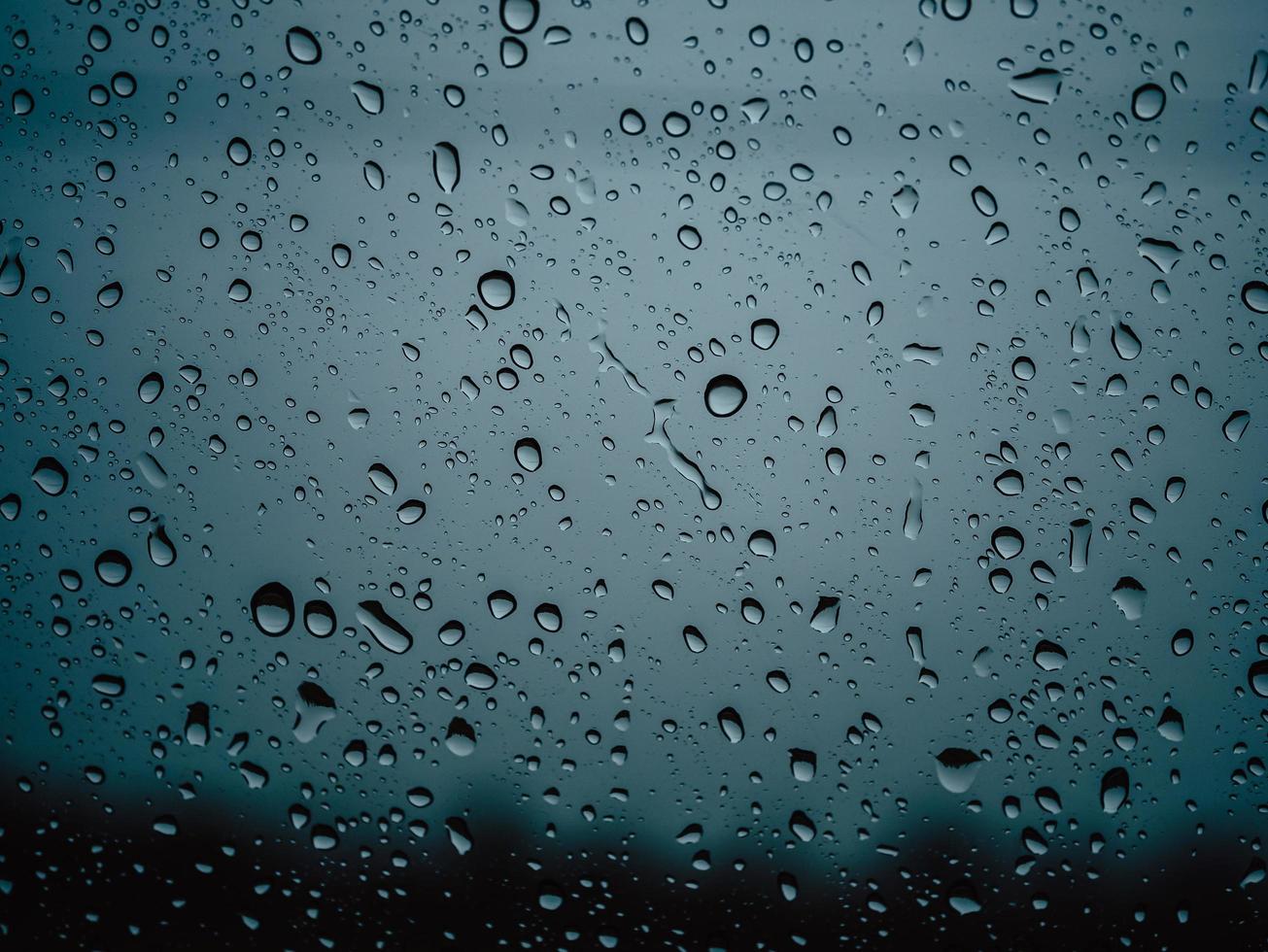 Closeup raindrops on glass car in the rainy season. photo