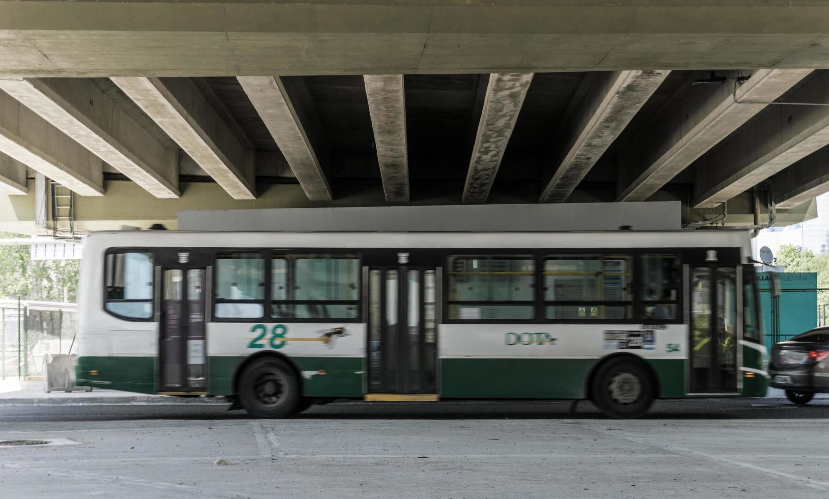 Buenos Aires, Argentina, 2019. Bus on the move under bridge photo