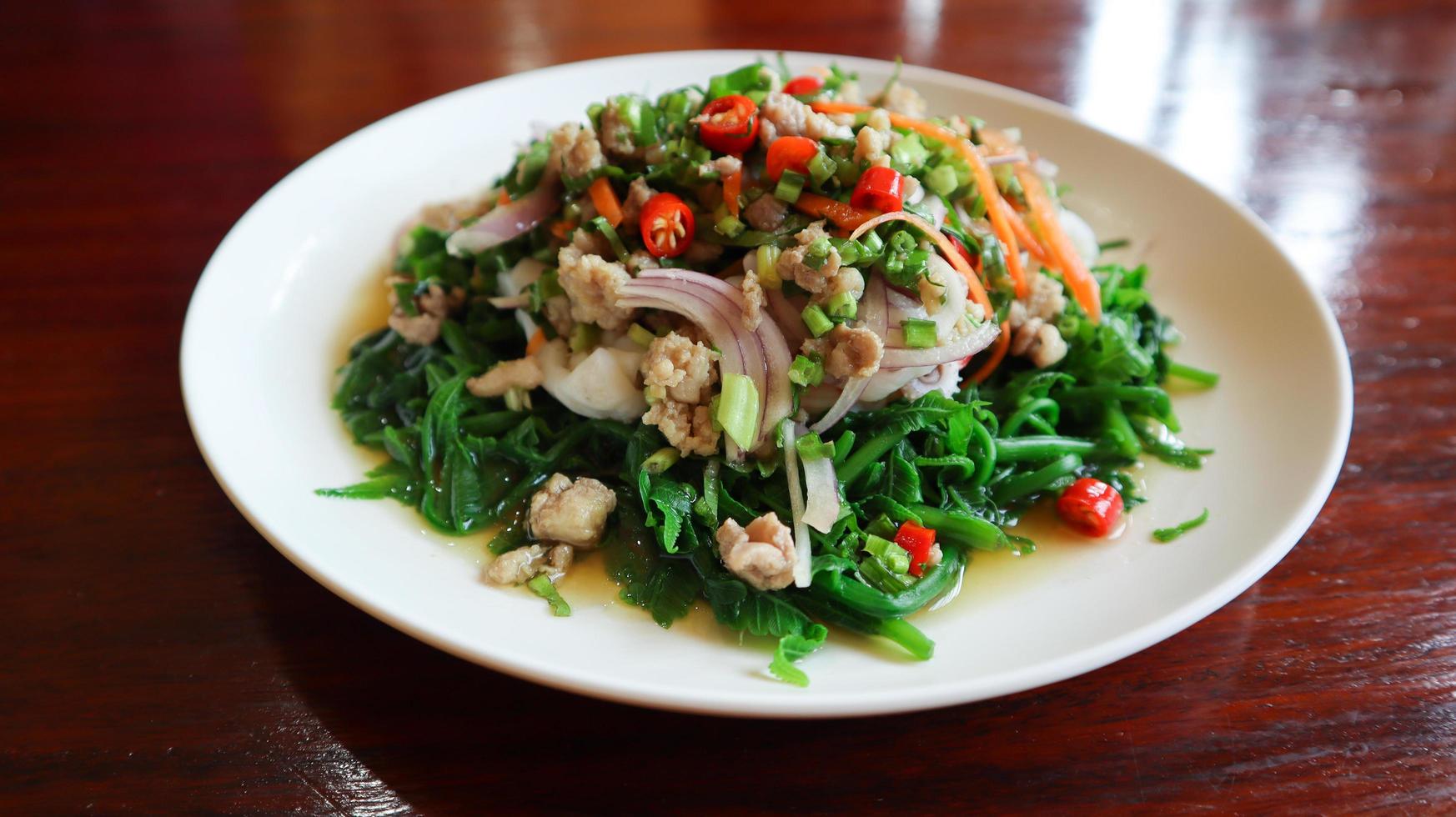 Spicy paco fern salad on white plate. photo