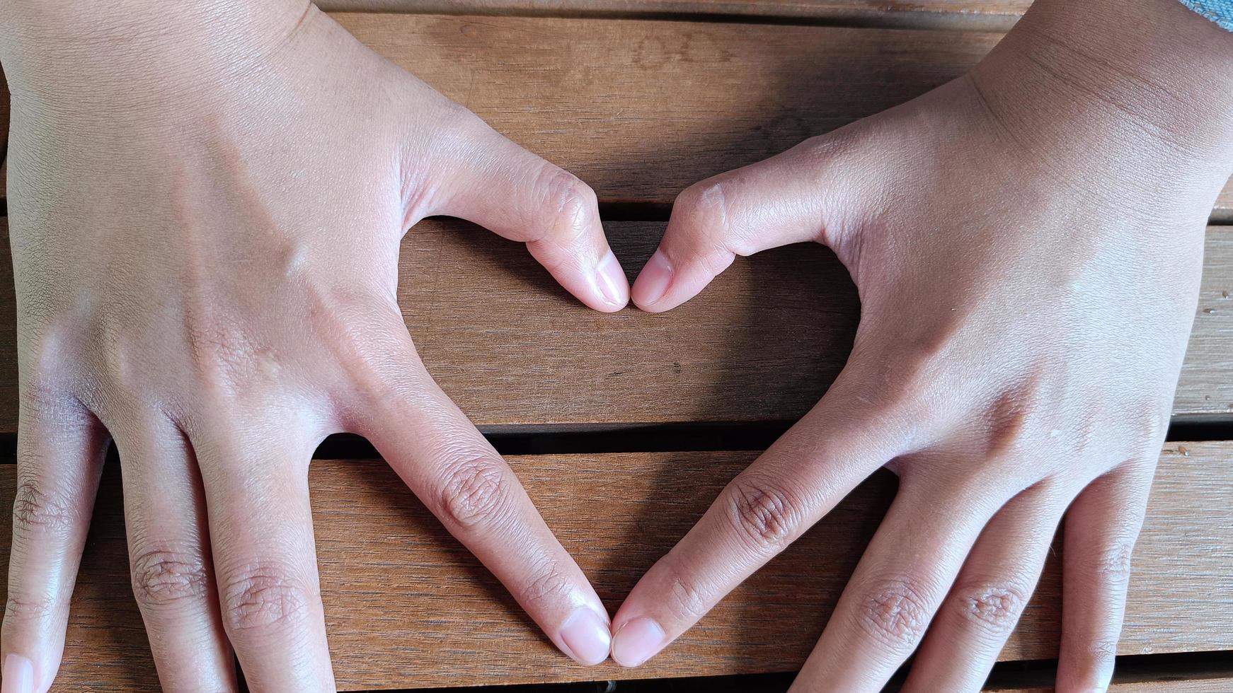 Male and female couple hands in shape of love heart photo