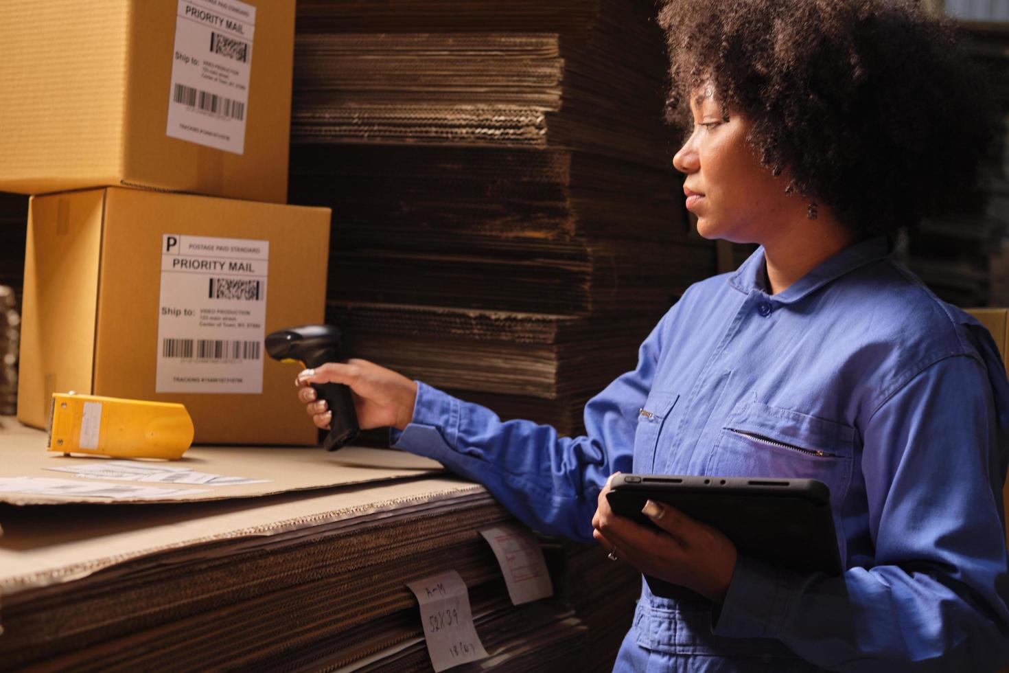 One female worker scan bar codes to check orders at parcels warehouse factory. photo