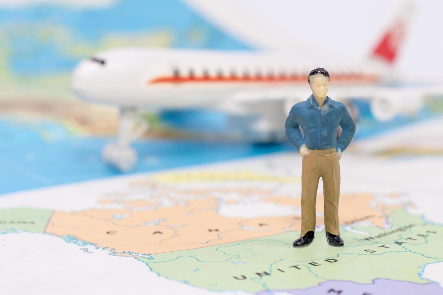 Miniature people, businessman standing on map American photo