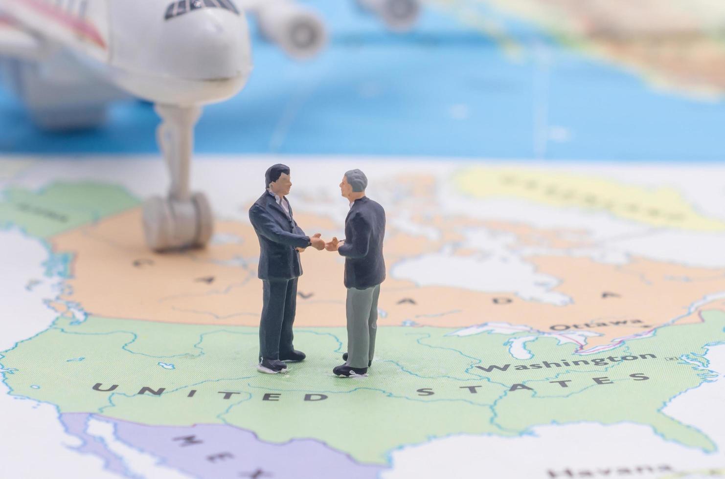 Miniature people, businessman standing on map American photo