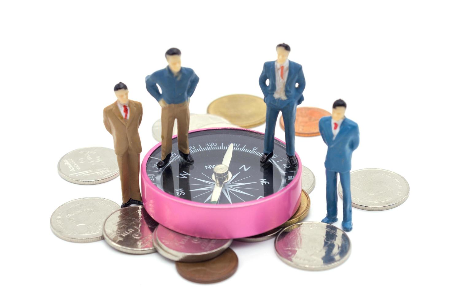 Miniature businessman and compass on coins stack on white background photo