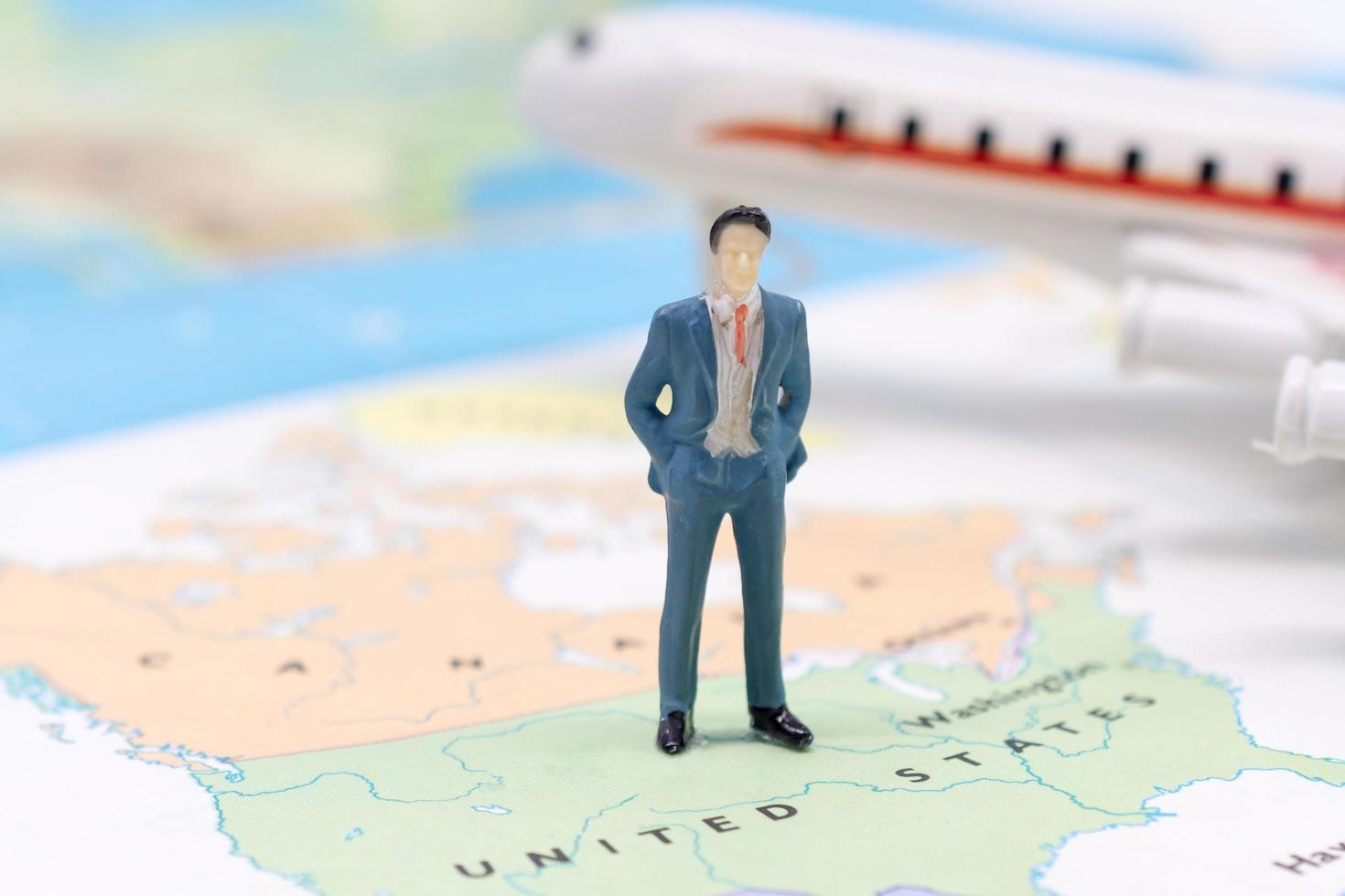 Miniature people, businessman standing on map American photo