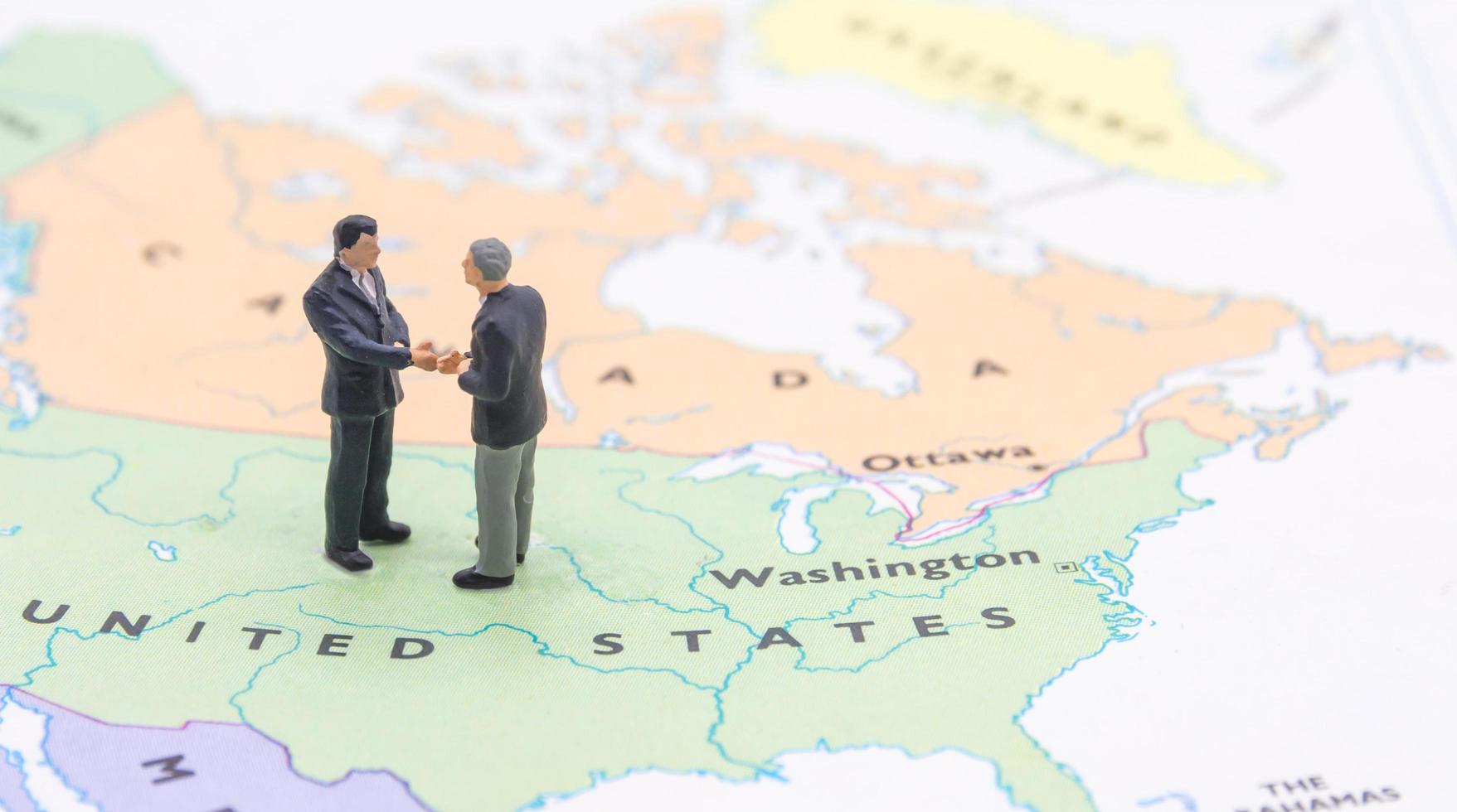 Miniature people, businessman standing on map American photo