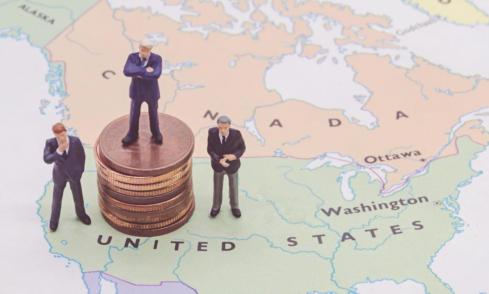 Miniature people, businessman standing on map American photo