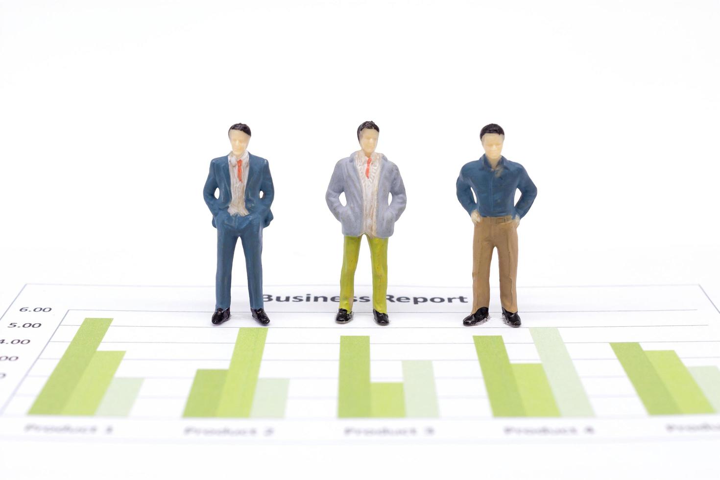 Miniature figures businessmen standing on a graph chart financial photo