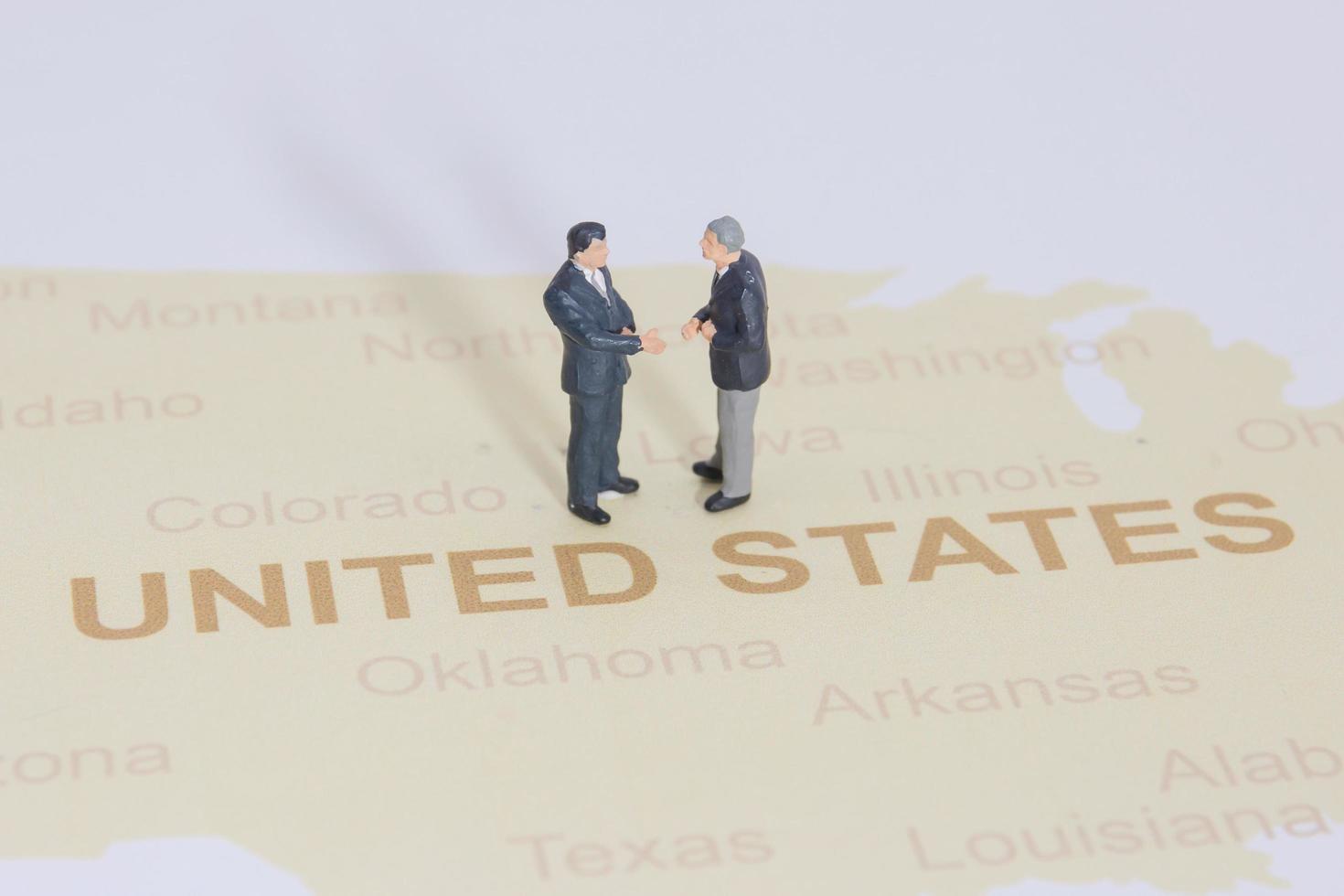 Miniature people, businessman standing on map American photo