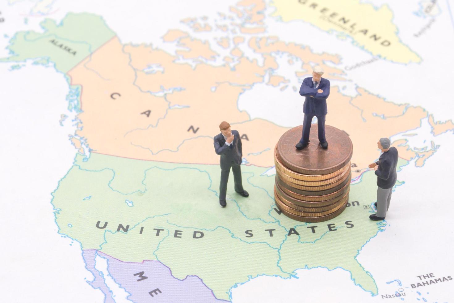 Miniature people, businessman standing on map American photo