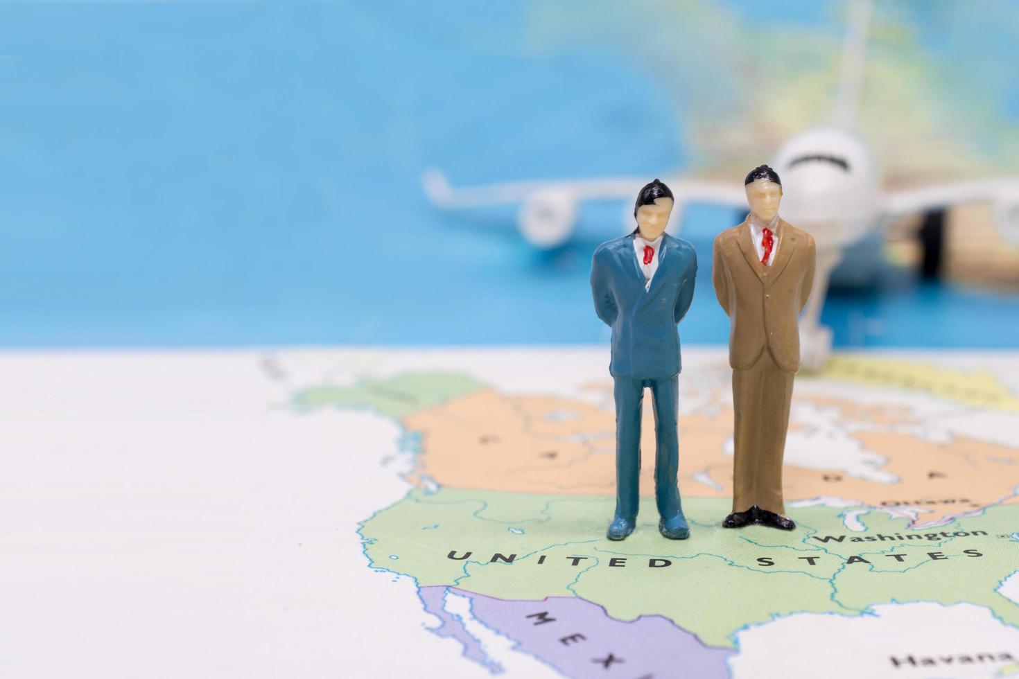 Miniature people, businessman standing on map American photo