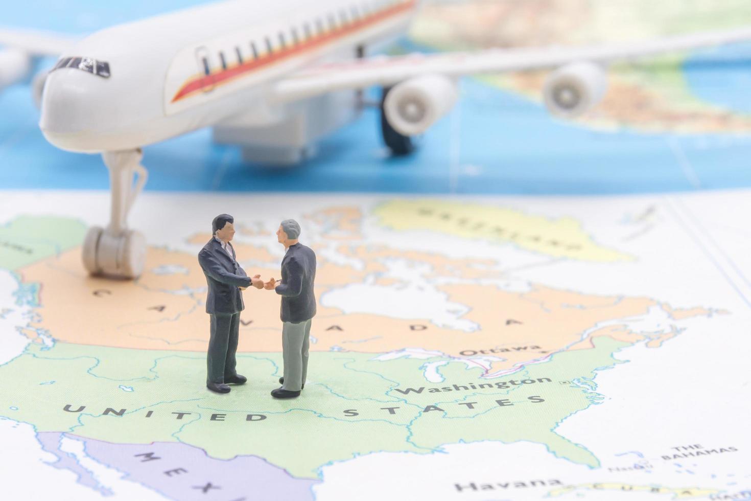 Miniature people, businessman standing on map American photo